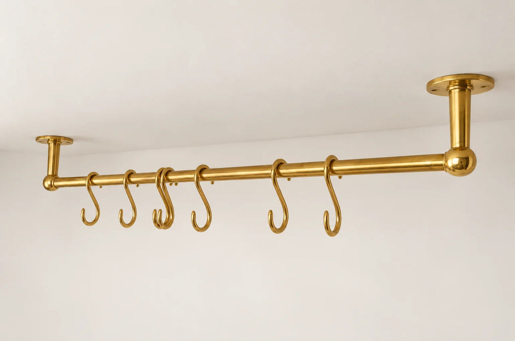 A brass ceiling-mounted clothing rack with six hanging hooks, shown against a plain white wall and ceiling.